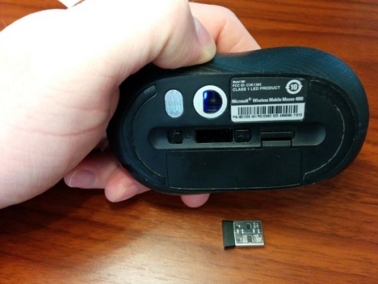Observe the USB dongle and the compartment on the underside of the mouse